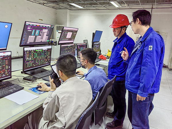 5月13日，動力車間三期鍋爐控制室，DCS改造工藝、儀表、電氣等部門聯(lián)合調(diào)試，車間主任姜軍虎與技術(shù)員畢加佳查看調(diào)試過程.jpg