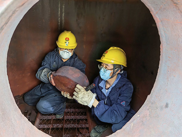 5月11日，動(dòng)力車(chē)間三期工藝除氧器內(nèi)部，黨員突擊隊(duì)隊(duì)員劉瑞斌和李震正在清理舊填料.jpg