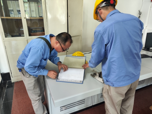 師帶徒，8月21日，老師傅王益在一期控制室為新員工胡含朗講解儀表設(shè)備圖紙.jpg
