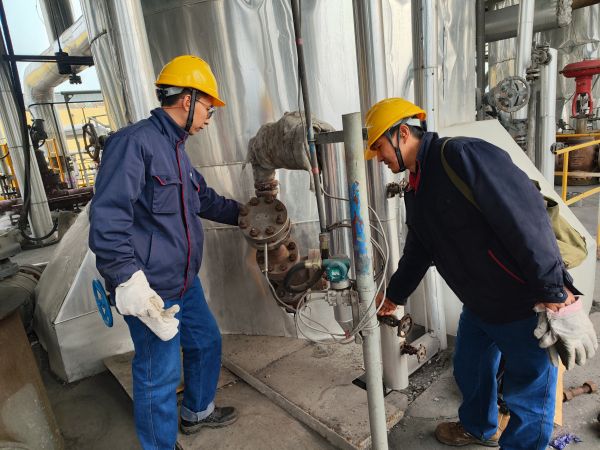 2月2日，計(jì)控電儀部李勝忠和胡含朗正在檢查氣化爐流量變送器的伴熱保溫情況.jpg