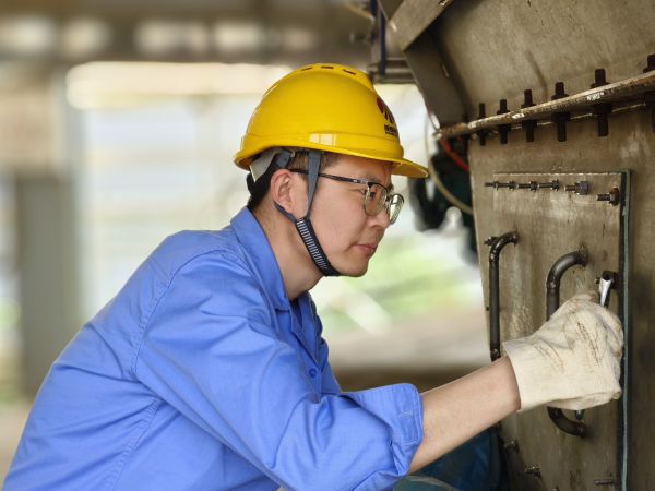 5月11日，尿素車間設(shè)備技術(shù)員馬強(qiáng)檢查設(shè)備螺栓是否松動(dòng).jpg